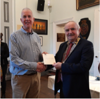 Richmond Rotary President Jos Huddleston presenting a cheque for £500 to David Walker of the Richmondshire Refugees Support Group at Richmond Town Hall.